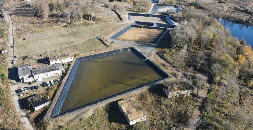 Drohnen Aufnahme der Pflanzenkläranlage aus der Höhe: Man sieht vier Becken der Constructed Wetlands hintereinander eingefügt im Landschaftsbild des Harz.